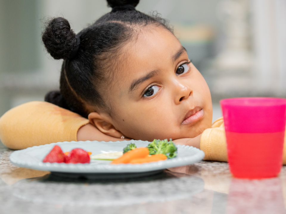 Child sitting at the dinner table and won't eat the food in front of her.