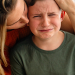 Mom consoling her son while he is crying