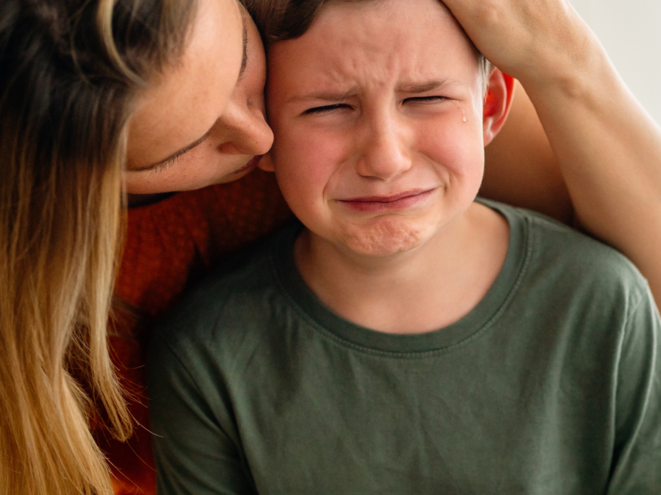 Mom consoling her son while he is crying